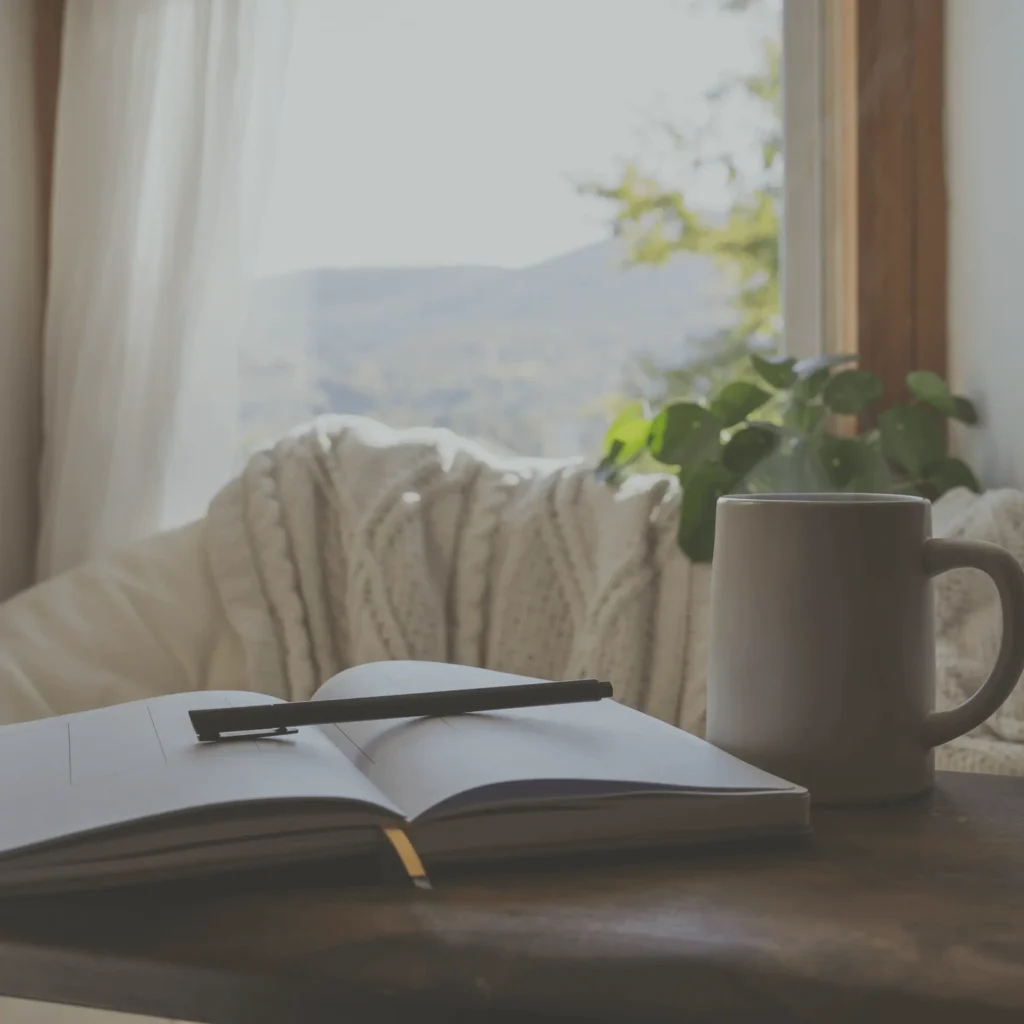 A cozy nook with an open journal and cup of coffee by Elle Mundus on Getty Images